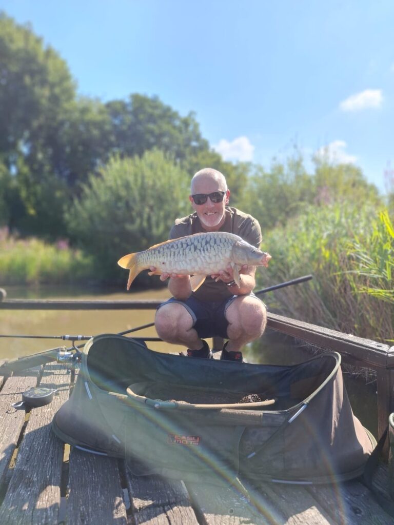 Guest with a carp caught on the pontoon at Scotgate Cottage fishing lake