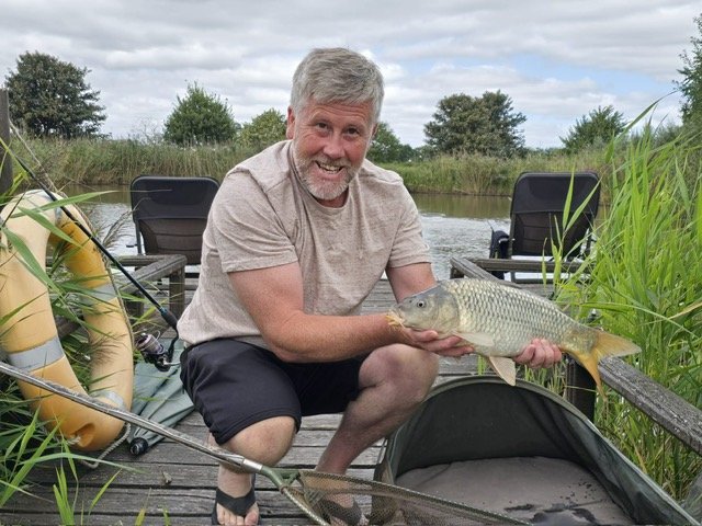 Guest fishing at Scotgate Cottage holding a common carp