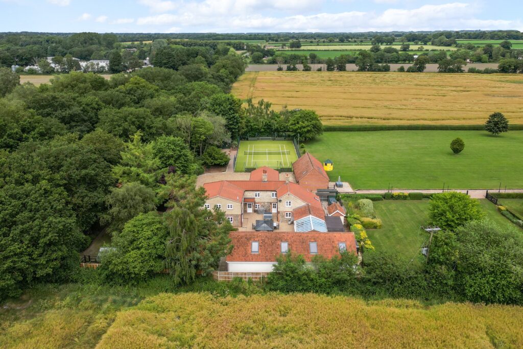 Aerial view of Scotgate Cottages grounds, tennis court and Norfolk parkland
